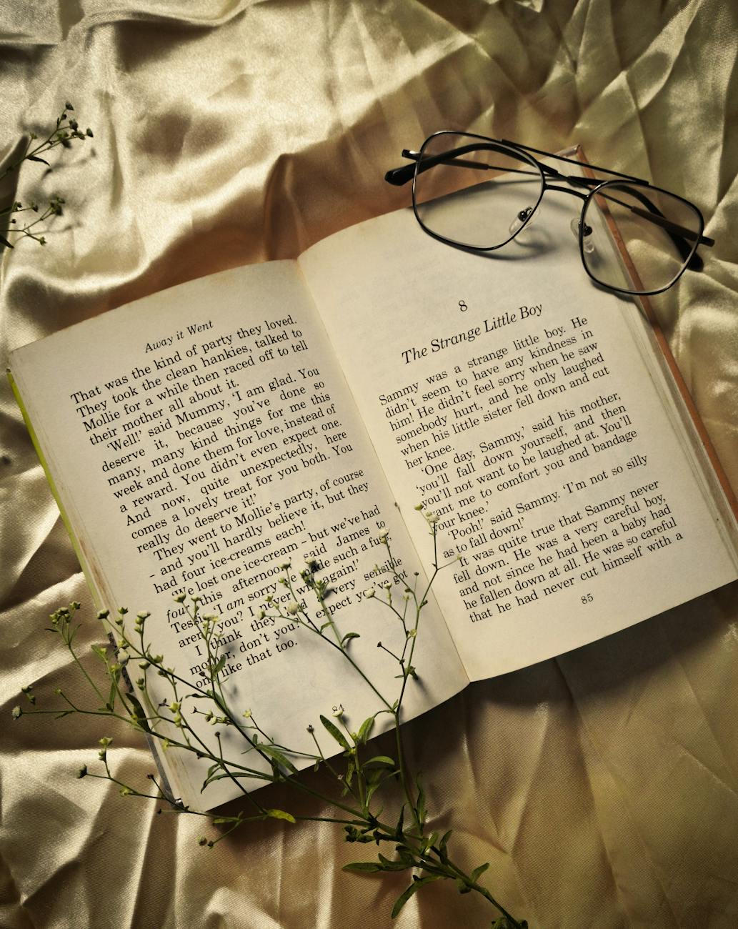 cozy book and glasses on satin fabric